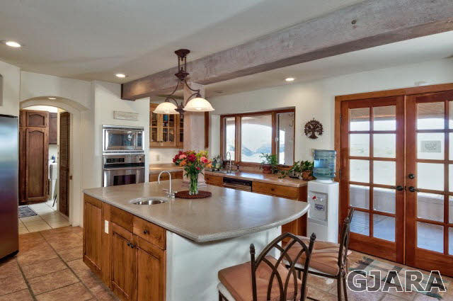 3412 D Road Palisade, CO 81526 - Photo 8 of 9 a kitchen with a dining table chairs stainless steel appliances and cabinets