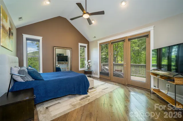 a bed sitting in a bedroom next to a window and a chandelier
