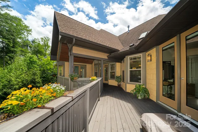 a balcony with wooden floor table and chairs
