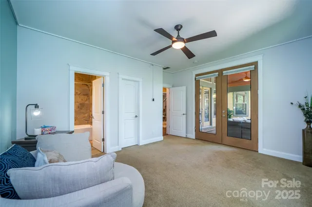 a bed sitting in a bedroom next to a window and a chandelier