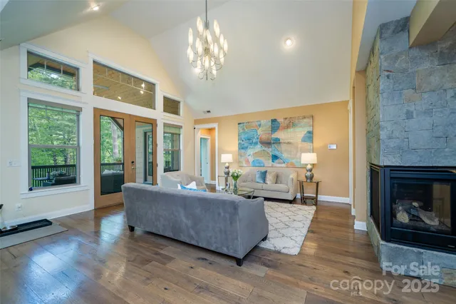 a living room with furniture large window and wooden floor