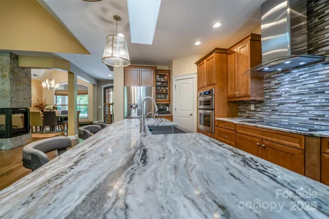 a large kitchen with stainless steel appliances a large counter top oven and cabinets