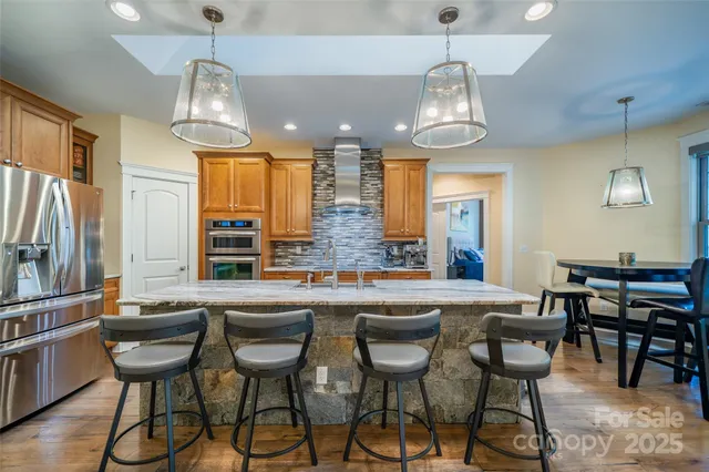 a kitchen with stainless steel appliances a dining table and chairs