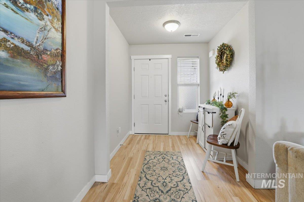 16682 Loggia Avenue Caldwell, ID 83607 - Photo 13 of 46 Foyer entrance with a textured ceiling and light wood-type flooring