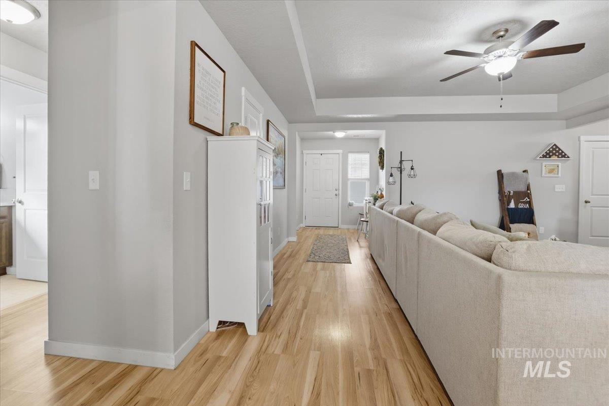 16682 Loggia Avenue Caldwell, ID 83607 - Photo 14 of 46 Living room featuring a raised ceiling, light wood-type flooring, and a ceiling fan