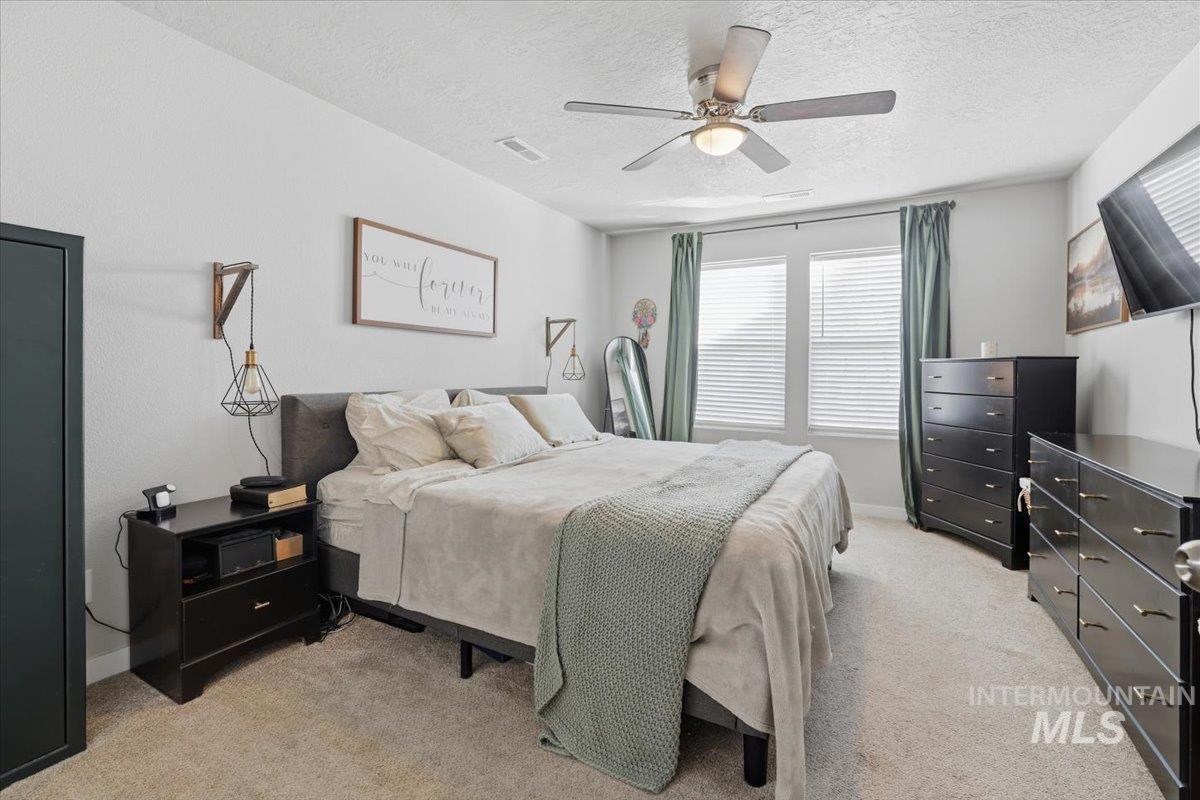 16682 Loggia Avenue Caldwell, ID 83607 - Photo 23 of 46 Bedroom with light carpet, ceiling fan, and a textured ceiling