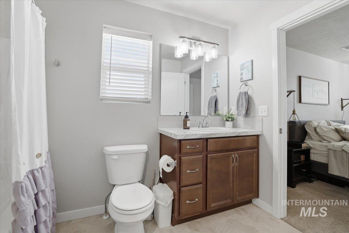 16682 Loggia Avenue Caldwell, ID 83607 - Photo 28 of 46 Ensuite bathroom featuring vanity, a shower with shower curtain, and a textured ceiling