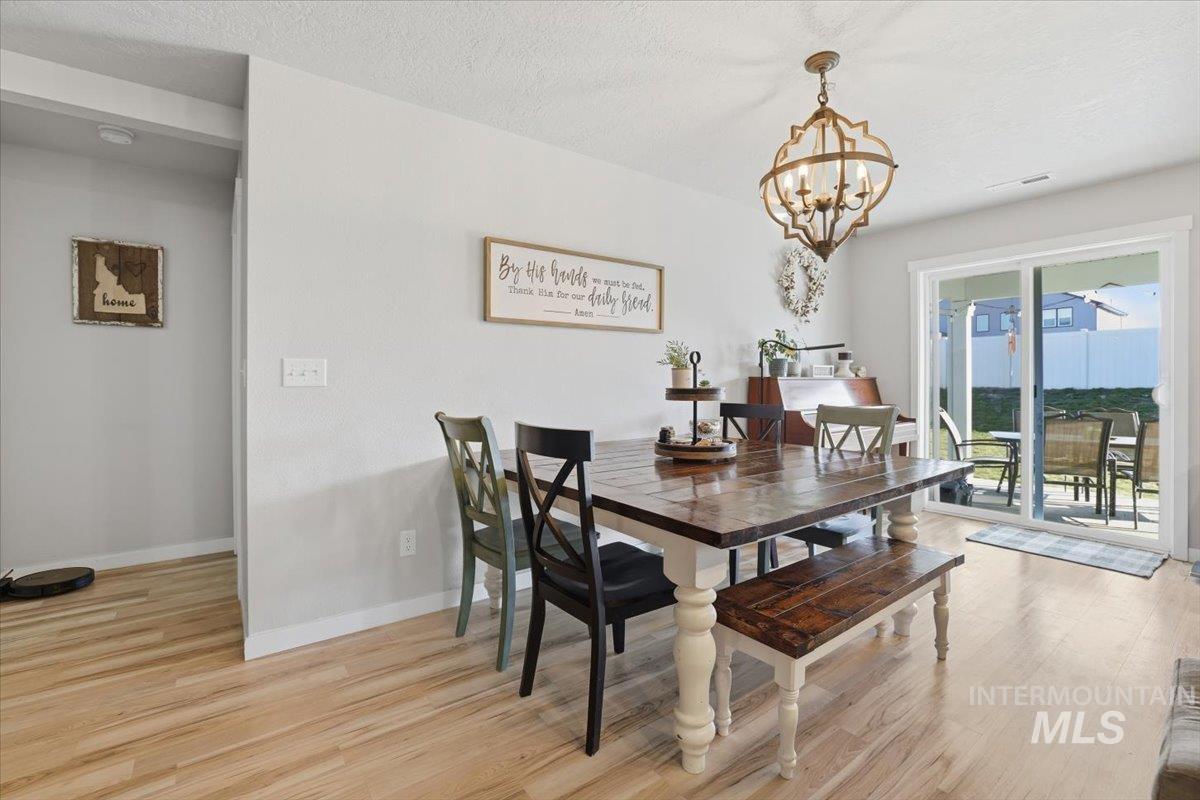 16682 Loggia Avenue Caldwell, ID 83607 - Photo 30 of 46 Dining space featuring light wood finished floors, suspended lighting, and a textured ceiling