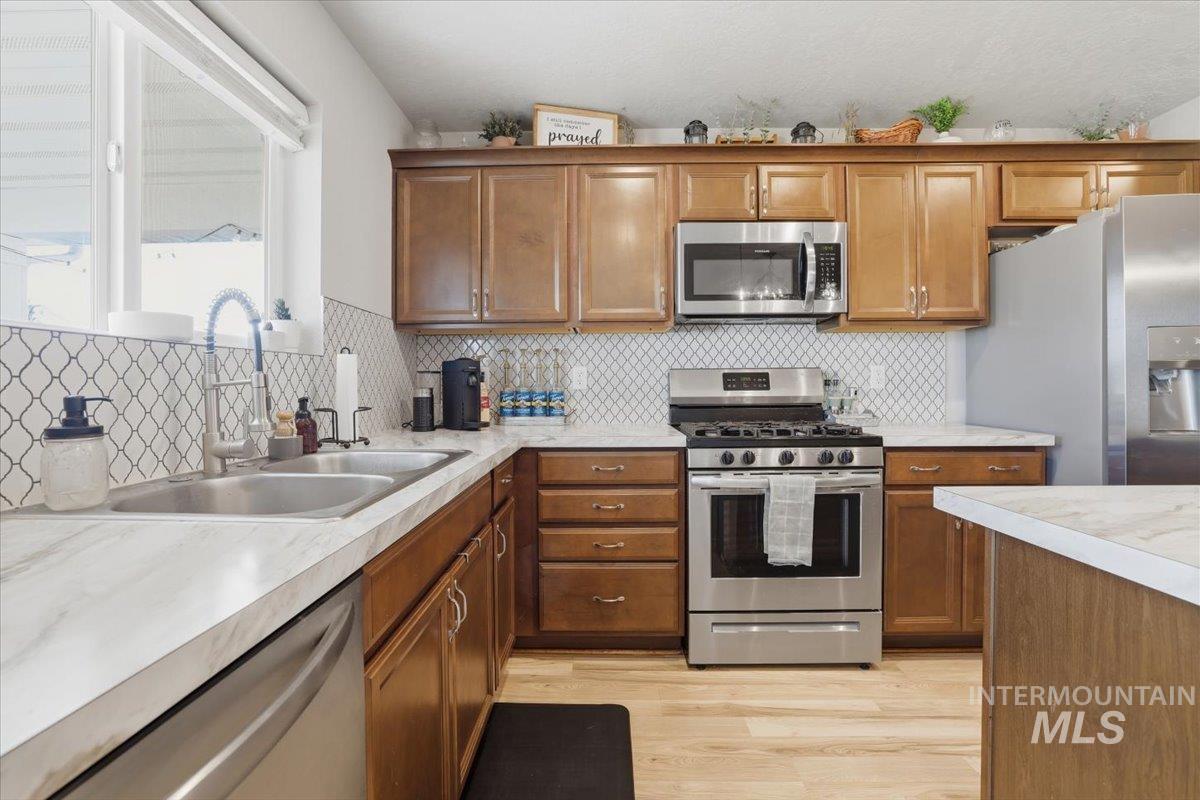 16682 Loggia Avenue Caldwell, ID 83607 - Photo 32 of 46 Kitchen with stainless steel appliances, wood finish cabinetry, light countertops, and light wood-type flooring