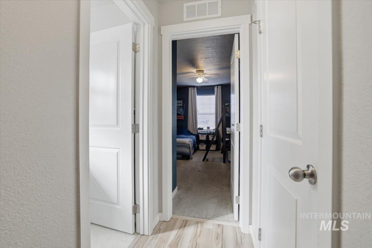 16682 Loggia Avenue Caldwell, ID 83607 - Photo 35 of 46 Hallway with a textured ceiling, a textured wall, and light wood-type flooring