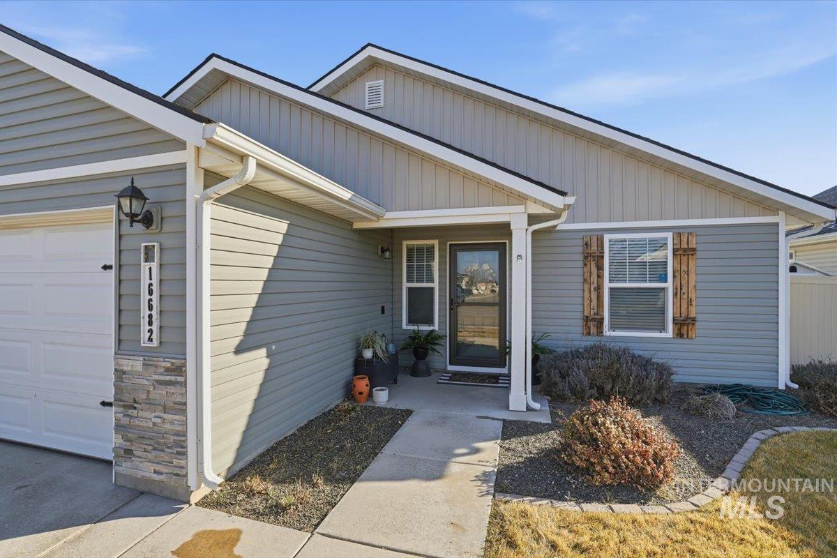 16682 Loggia Avenue Caldwell, ID 83607 - Photo 4 of 46 View of exterior entry featuring an attached garage and stone siding