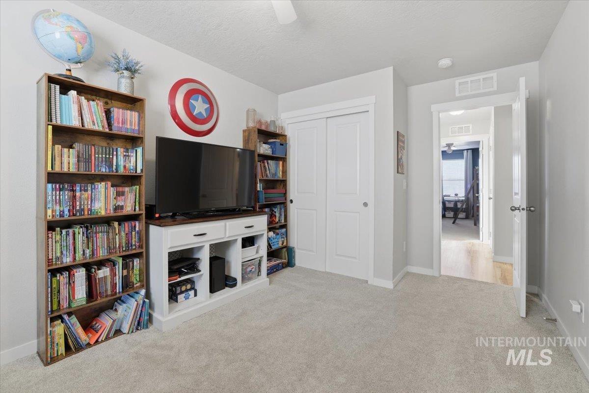 16682 Loggia Avenue Caldwell, ID 83607 - Photo 40 of 46 Living area with light colored carpet, a textured ceiling, and ceiling fan