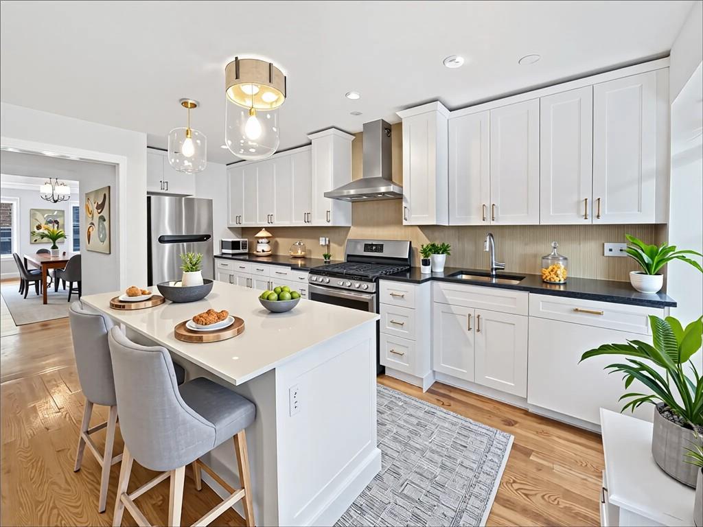 13 Windsor Place Brooklyn, NY 11215 - Photo 10 of 40 a kitchen with stainless steel appliances granite countertop a stove a sink dishwasher a stove a dining table with chairs and white cabinets with wooden floor