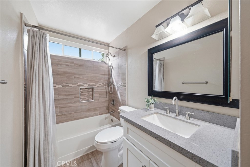 259 Scenic Way Brea, CA 92821 - Photo 39 of 62 a bathroom with a granite countertop sink toilet a mirror and bathtub