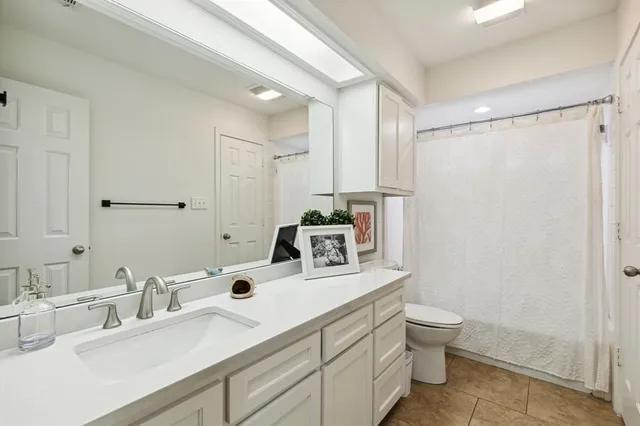 a bathroom with a sink toilet double vanity and tub