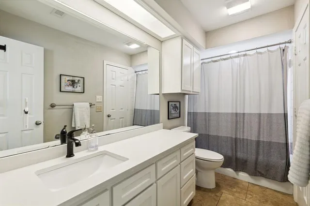 a bathroom with a sink a toilet and a shower