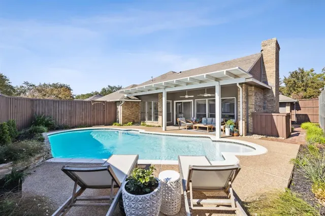 a view of a house with swimming pool and sitting area