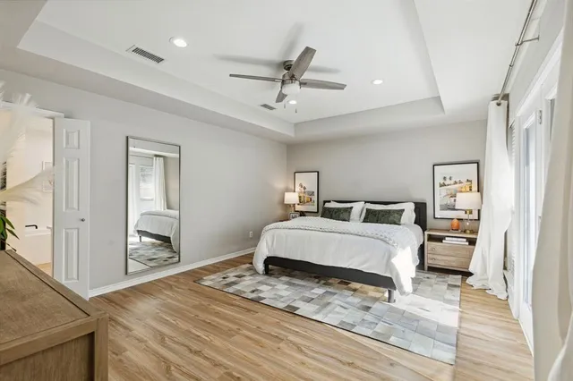 a spacious bedroom with a bed and wooden floor