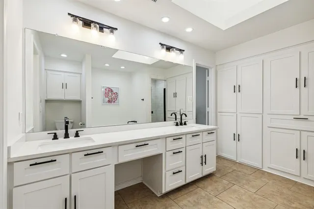 a bathroom with a double vanity sink and mirror