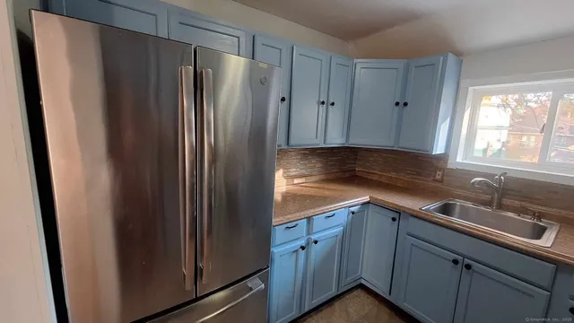 a kitchen with stainless steel appliances granite countertop a refrigerator and a sink