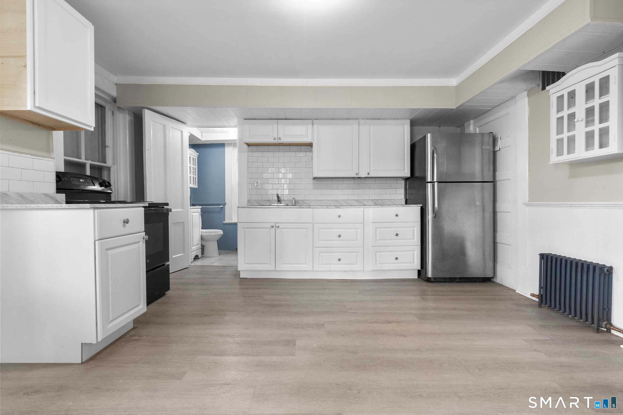a kitchen with a refrigerator a stove top oven and cabinets
