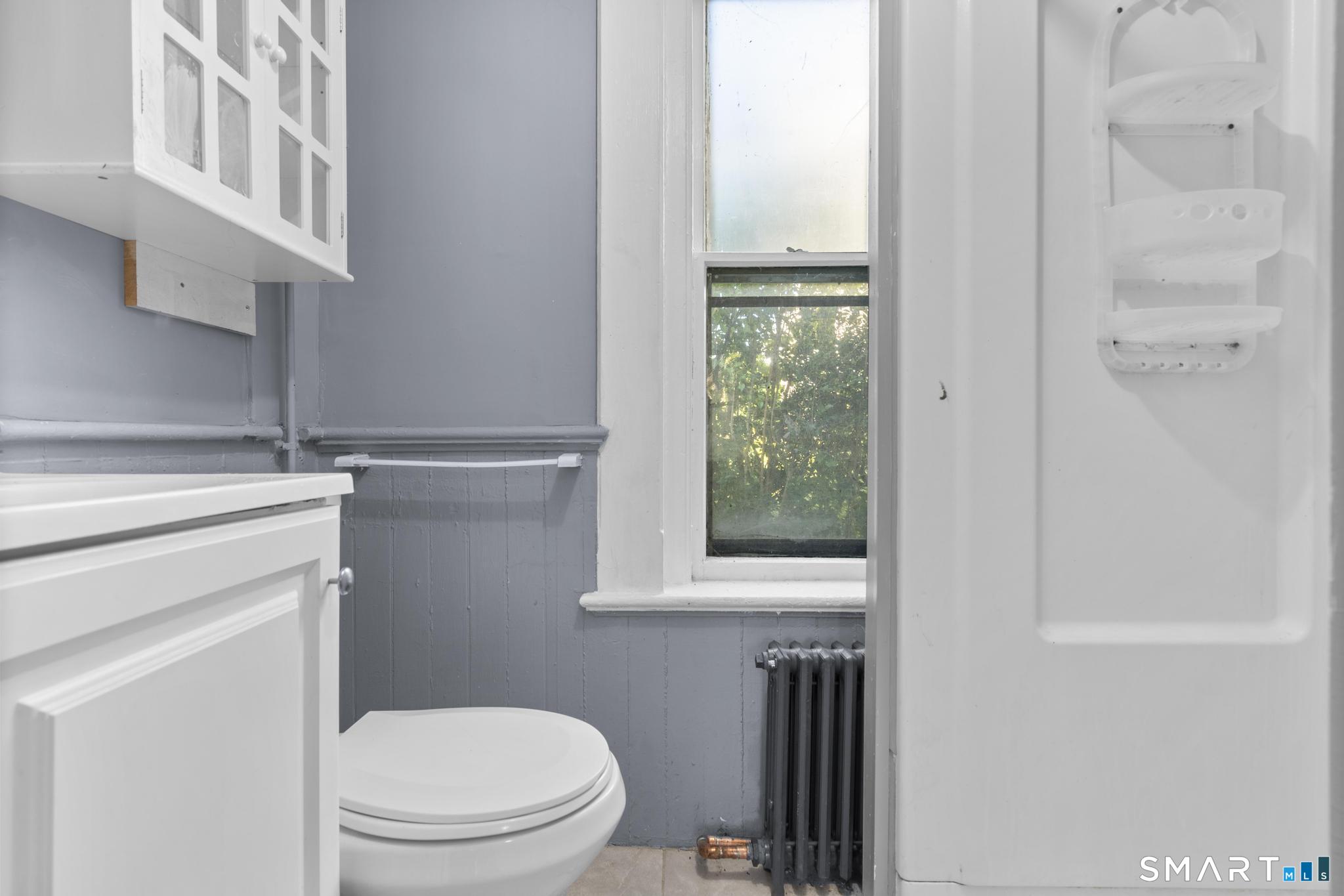 18 Hobart Street Meriden, CT 06450 - Photo 12 of 16 a bathroom with a toilet a sink and a window