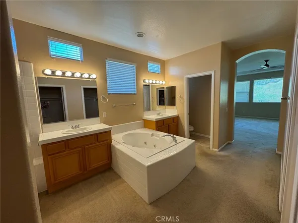 a bathroom with a double vanity sink mirror and bathtub