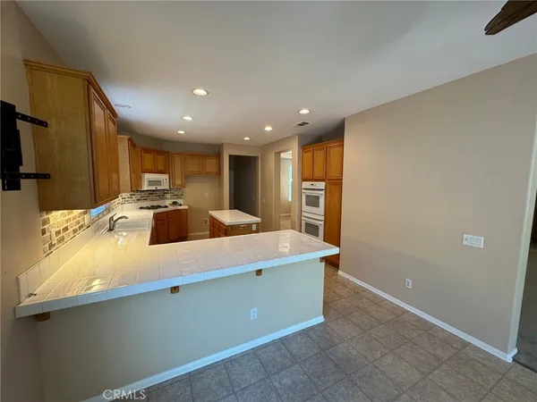 a view of kitchen with stainless steel appliances granite countertop a sink and a refrigerator