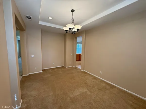 wooden floor in an empty room with a chandelier fan