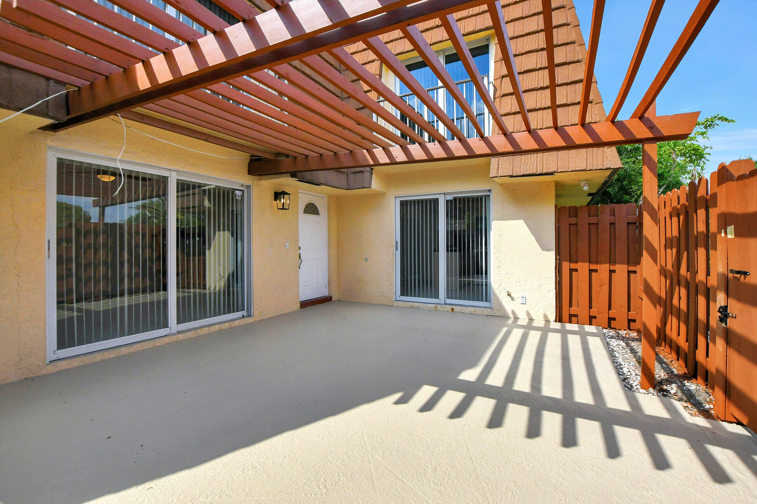a backyard of a house with wooden floor and iron fence