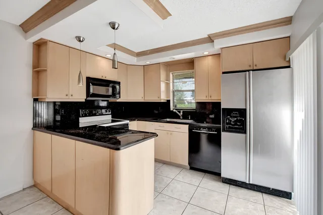 a kitchen with a refrigerator a stove a microwave and cabinets