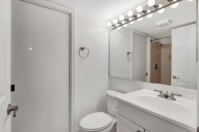 a bathroom with a toilet a sink and mirror