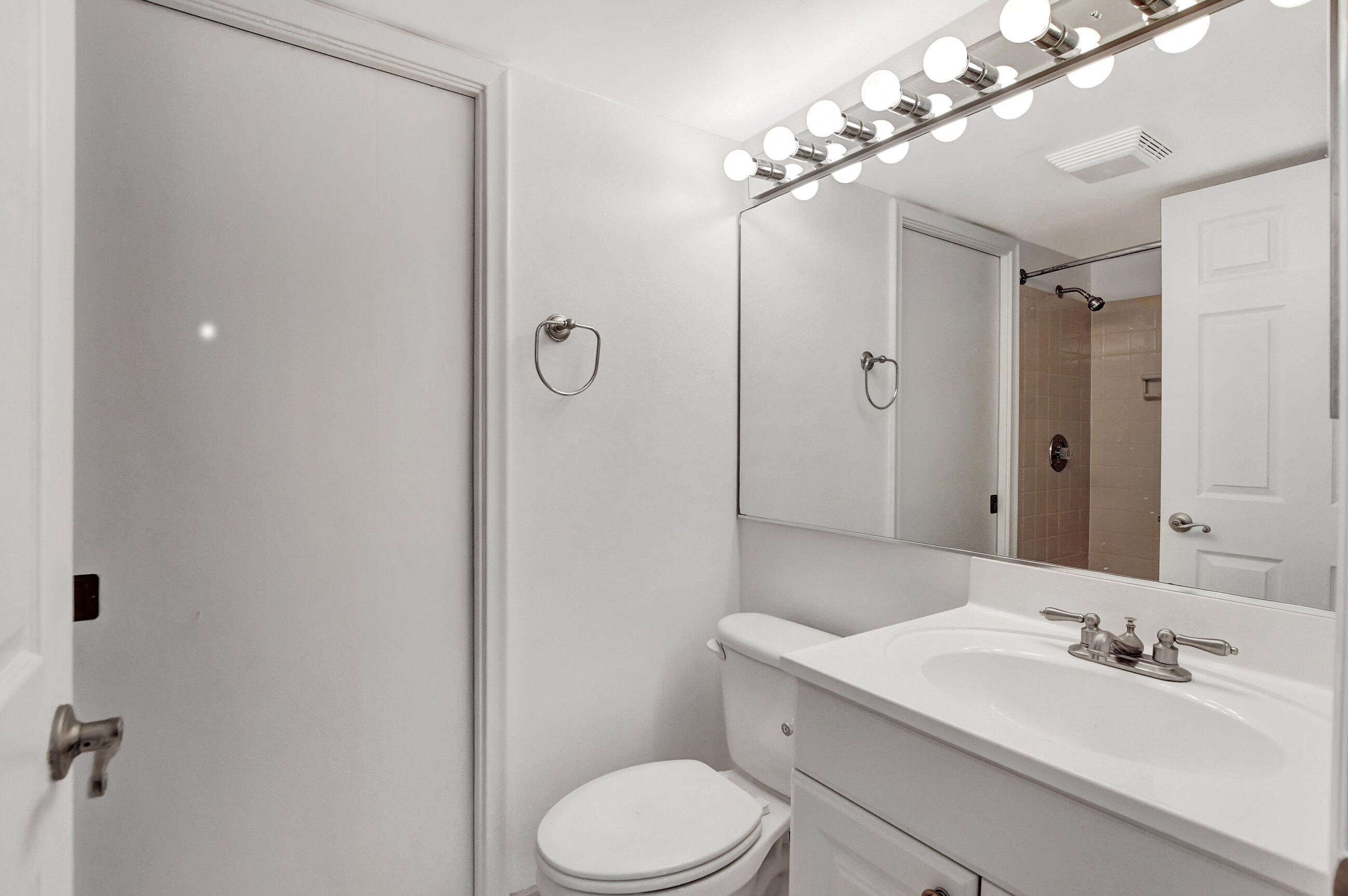 2555 Albatross Road North, Unit 2A Delray Beach, FL 33444 - Photo 14 of 27 a bathroom with a toilet a sink and mirror