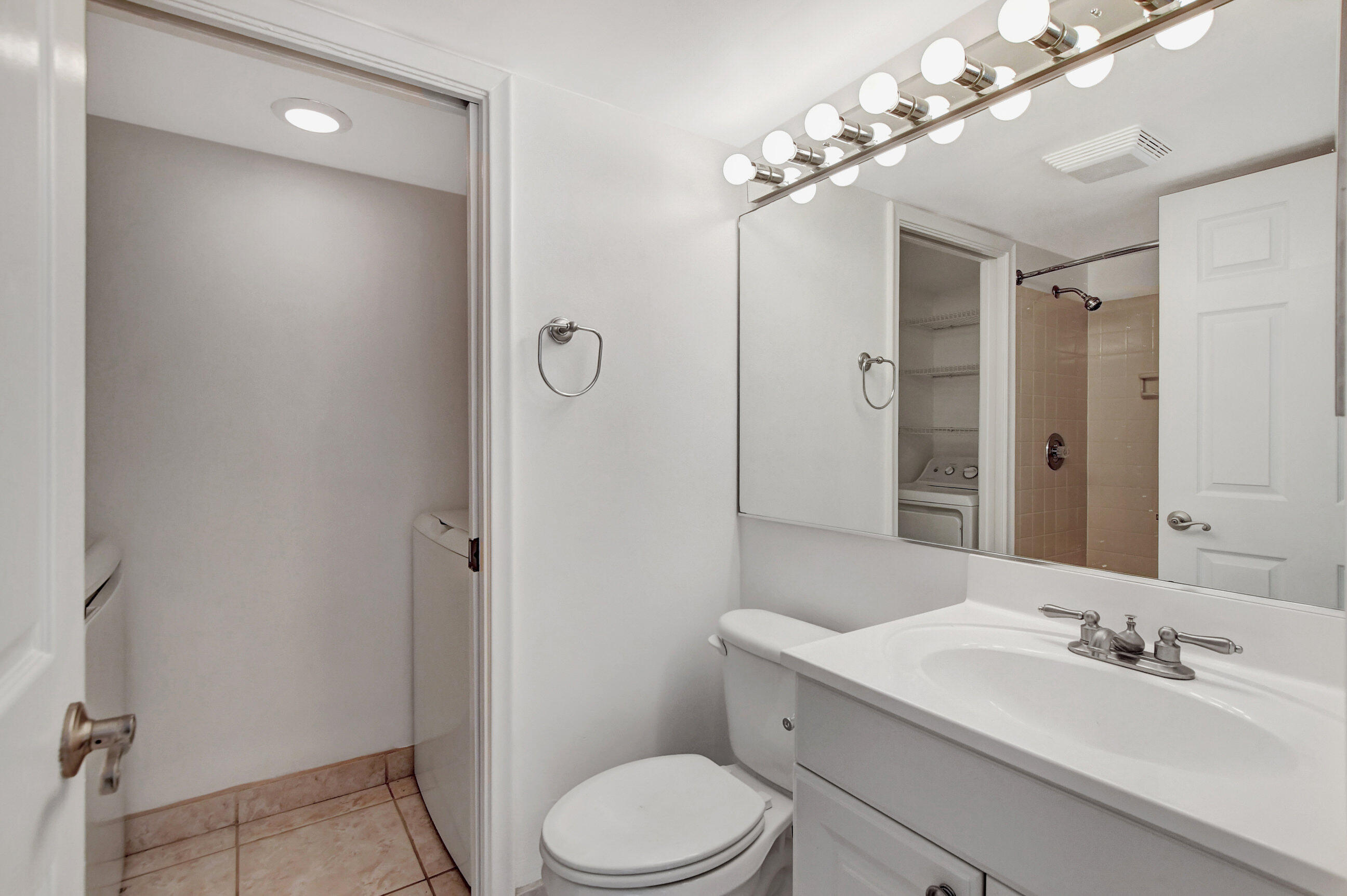 2555 Albatross Road North, Unit 2A Delray Beach, FL 33444 - Photo 15 of 27 a bathroom with a toilet a sink a mirror a vanity and shower