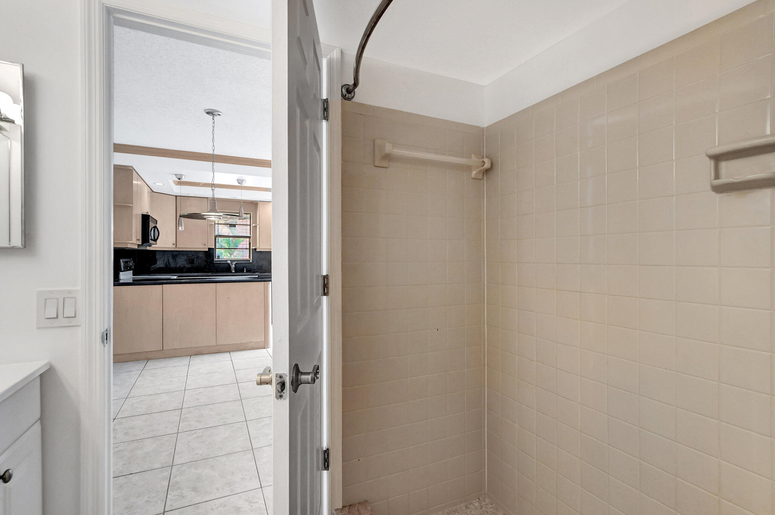 2555 Albatross Road North, Unit 2A Delray Beach, FL 33444 - Photo 17 of 27 a bathroom with a glass shower door and a sink