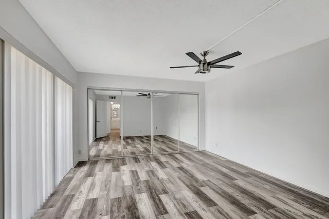 a view of a livingroom with a ceiling fan and wooden floor