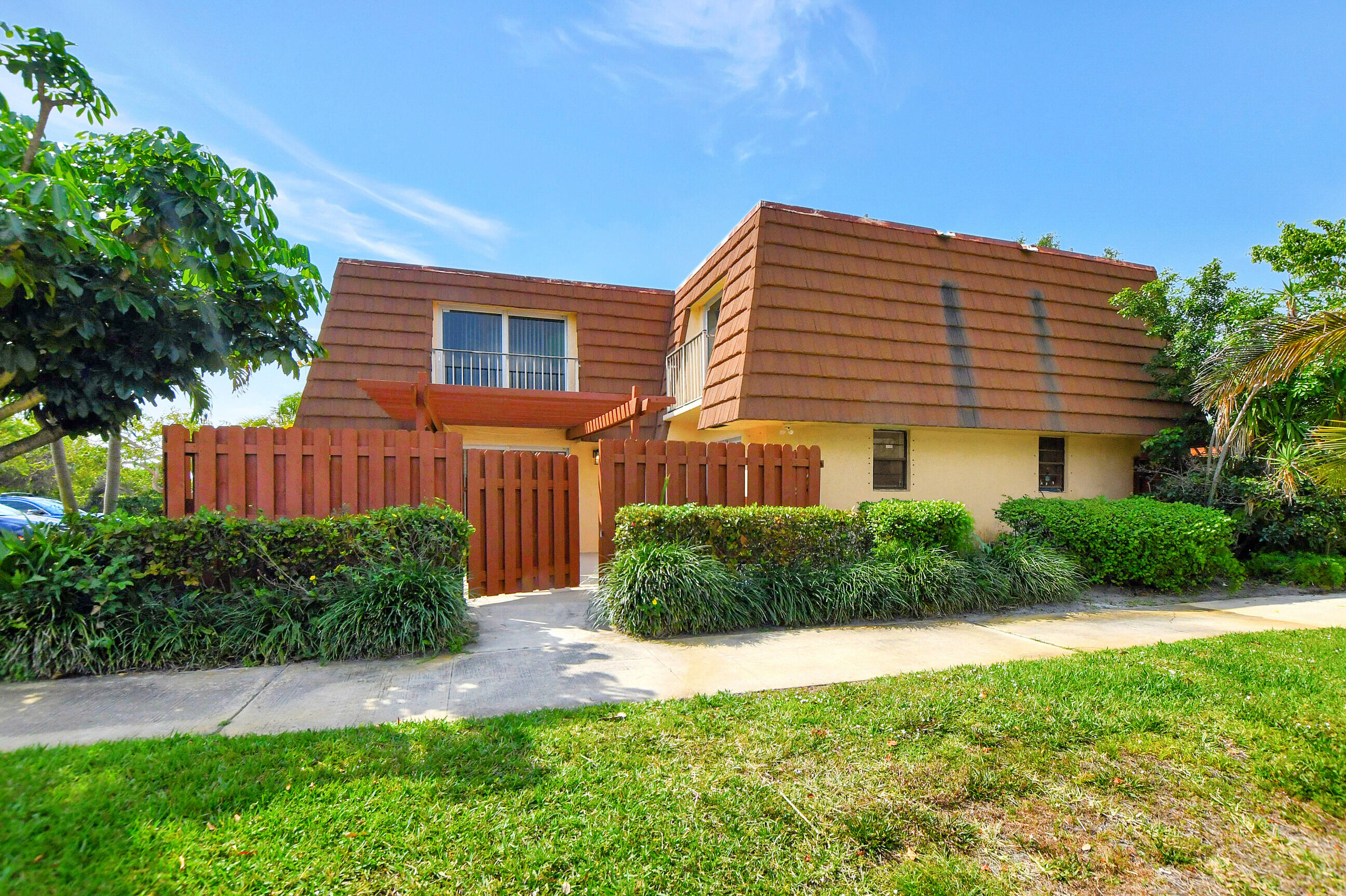 2555 Albatross Road North, Unit 2A Delray Beach, FL 33444 - Photo 2 of 27 a front view of a house with a yard