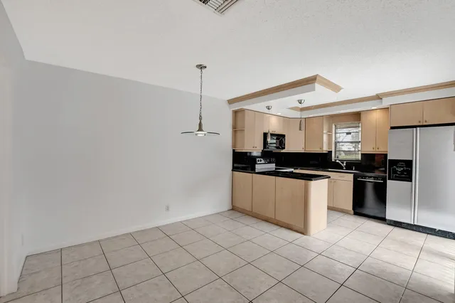 a large white kitchen with a stove a refrigerator and a counter top