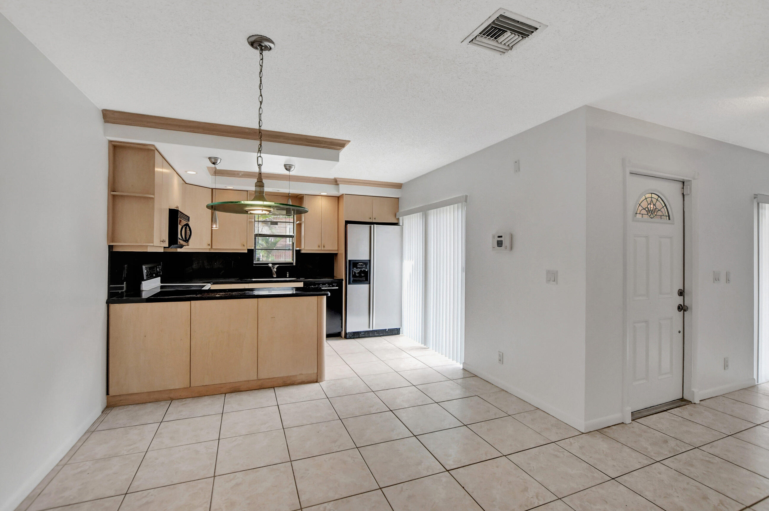 2555 Albatross Road North, Unit 2A Delray Beach, FL 33444 - Photo 10 of 27 a kitchen with stainless steel appliances granite countertop a refrigerator and a counter top space