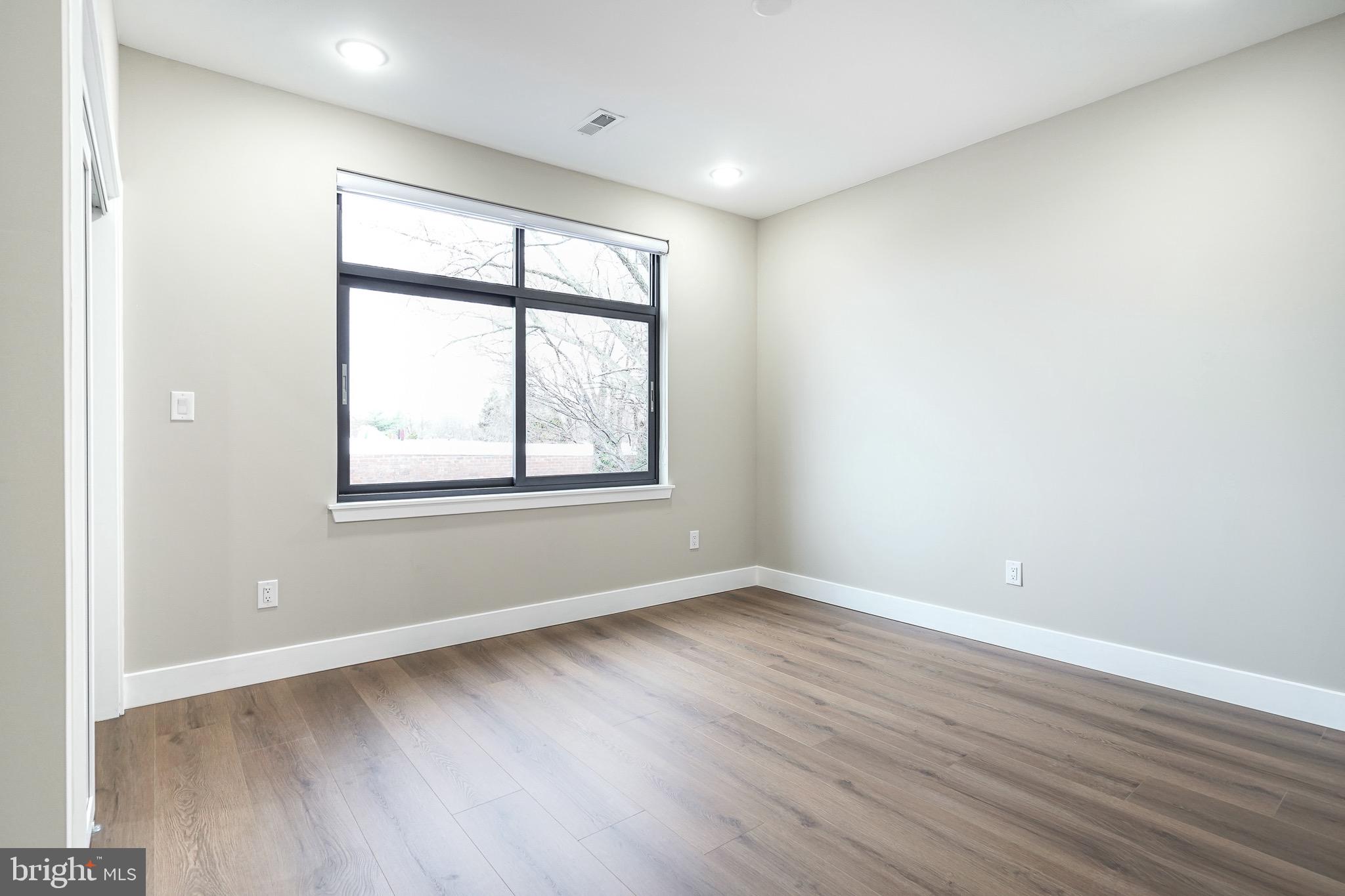 4432-00 Wingate Street, Unit 305 Philadelphia, PA 19136 - Photo 11 of 19 an empty room with wooden floor and windows