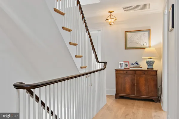 a view of staircase with wooden floor and white walls