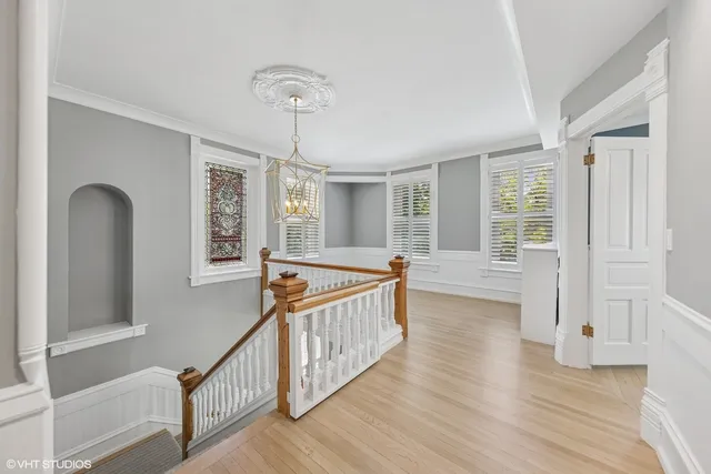 a view of staircase with wooden floor and white walls