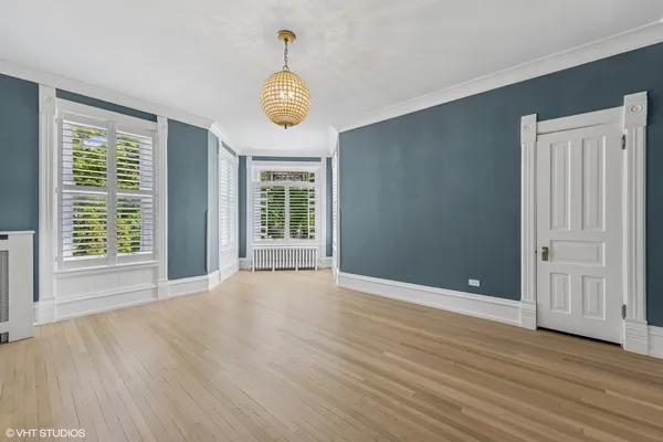 an empty room with wooden floor and fireplace