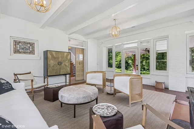 a living room with furniture a large window and a chandelier