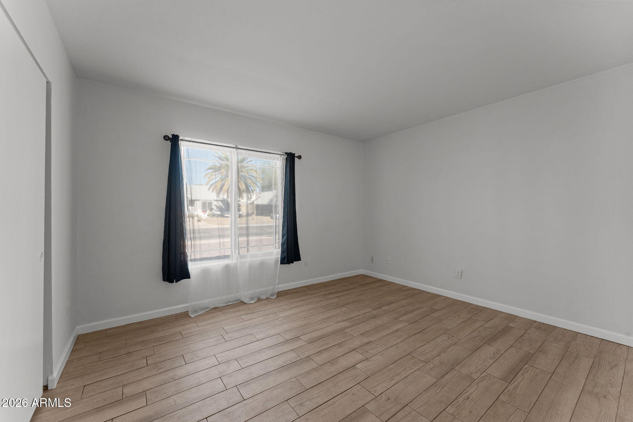 9257 West Gary Road Peoria, AZ 85345 - Photo 11 of 28 an empty room with wooden floor and windows
