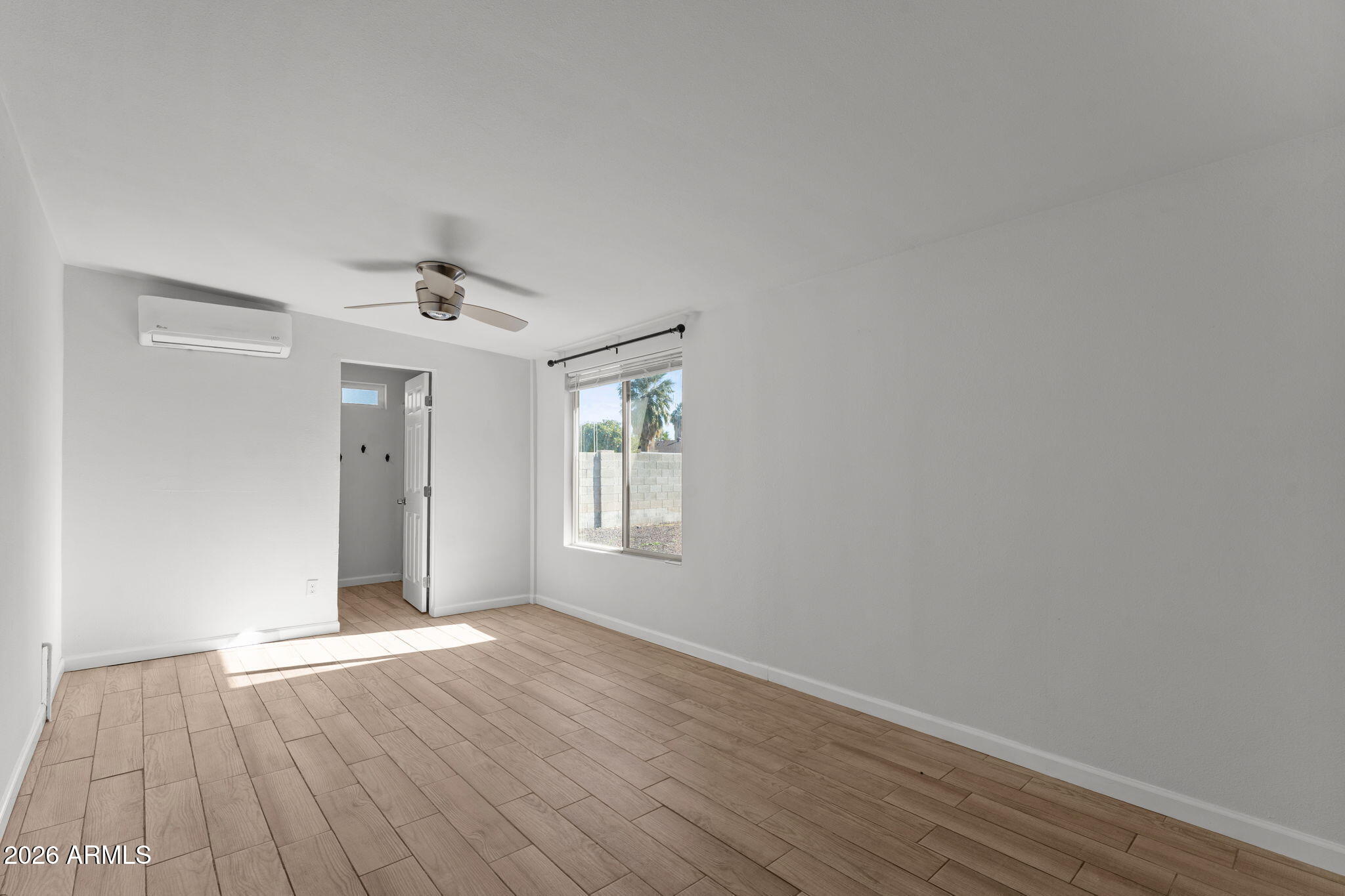 9257 West Gary Road Peoria, AZ 85345 - Photo 13 of 28 a view of an empty room with wooden floor and a window
