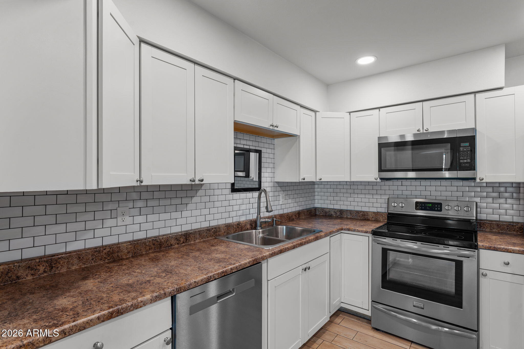 9257 West Gary Road Peoria, AZ 85345 - Photo 6 of 28 a kitchen with stainless steel appliances granite countertop a sink stove and microwave