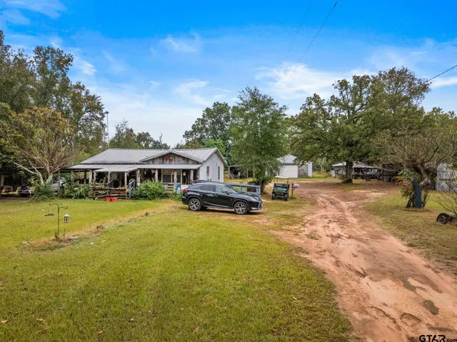 a view of a swimming pool with lawn chairs under an umbrella
