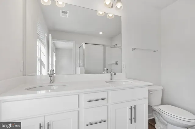 a bathroom with a sink a toilet a mirror and vanity