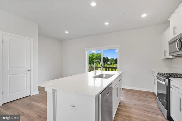 a kitchen with kitchen island a sink stove and wooden floor